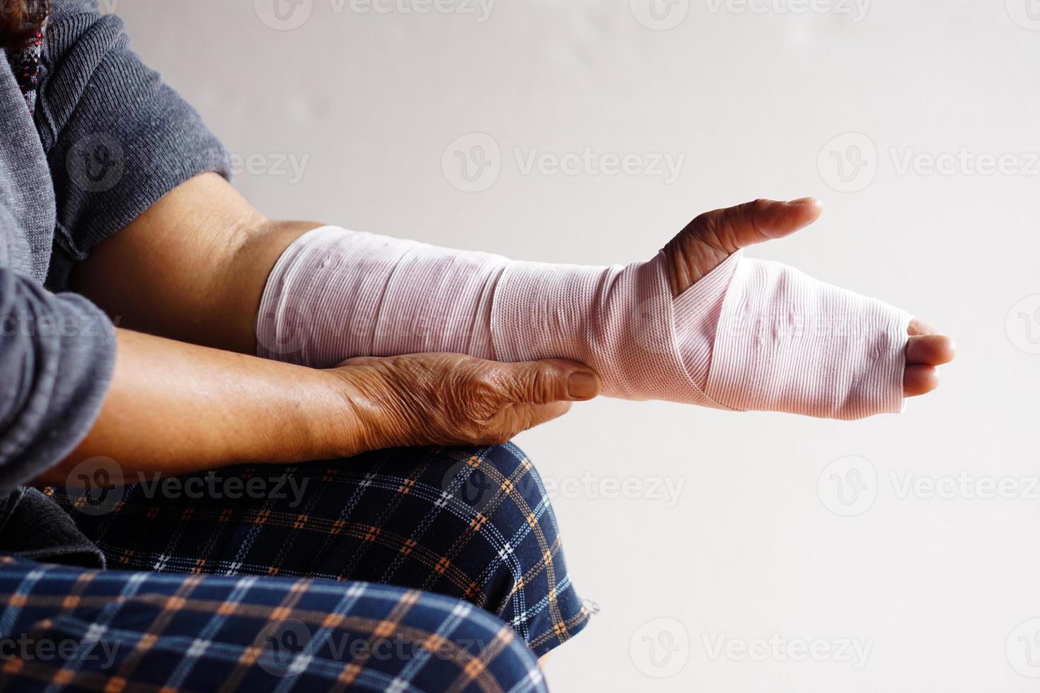 Closeup hand wrapped with bandage on sprain wrist, injury arm treatment. Concept, health problem, accident, first aid. Insurance. photo