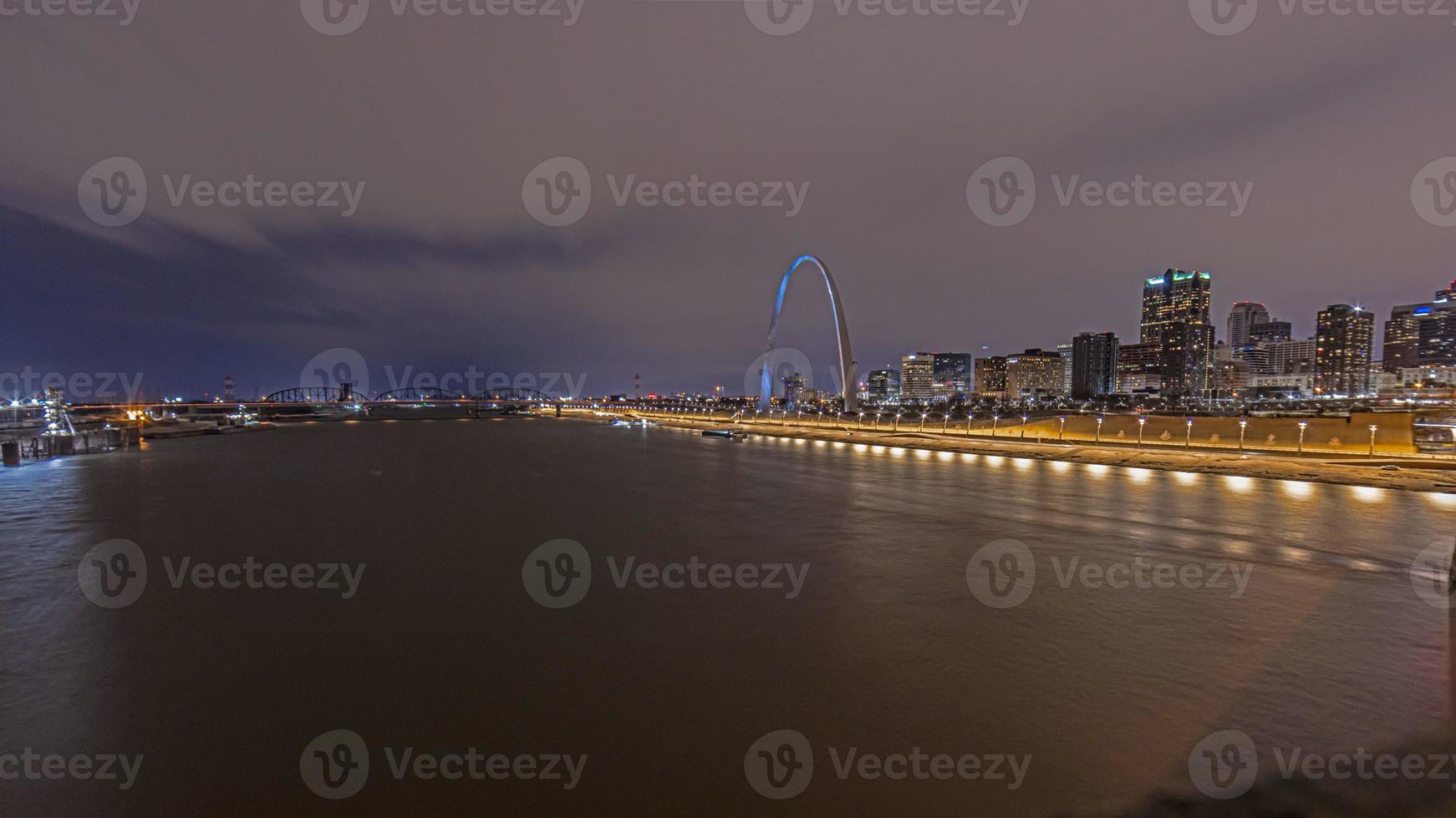 vista a través del río mississippi hasta el gran arco de st. luis en la noche foto