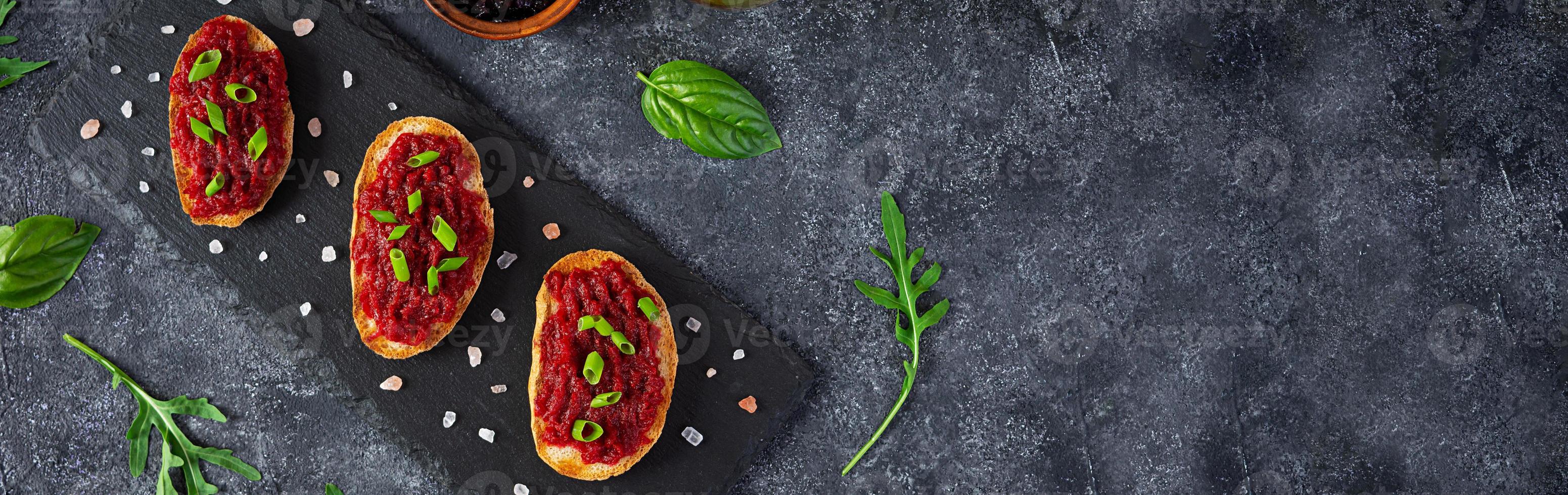 Bruschetta with grated beetroot, herbs and caramelized onion. Top view photo