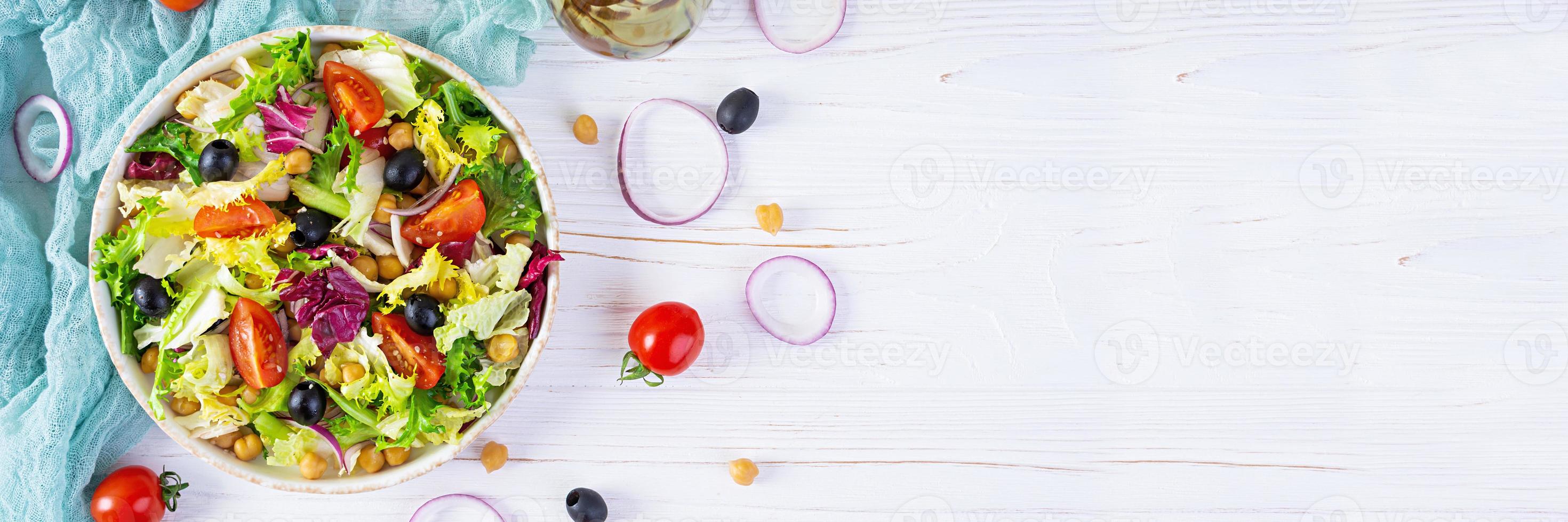 Vegetarian salad with chickpeas, tomatoes, olives and lettuce. Diet salad food photo