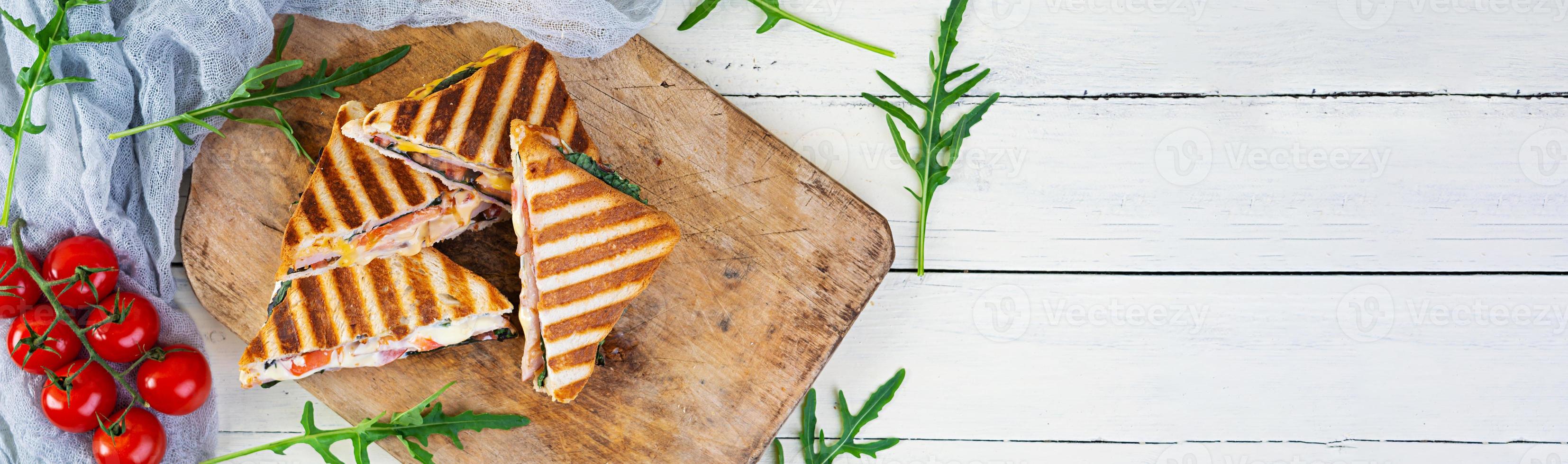 Sandwich with ham, cheese, mustard leaves, tomatoes and onion. Tasty grilled sandwiches photo