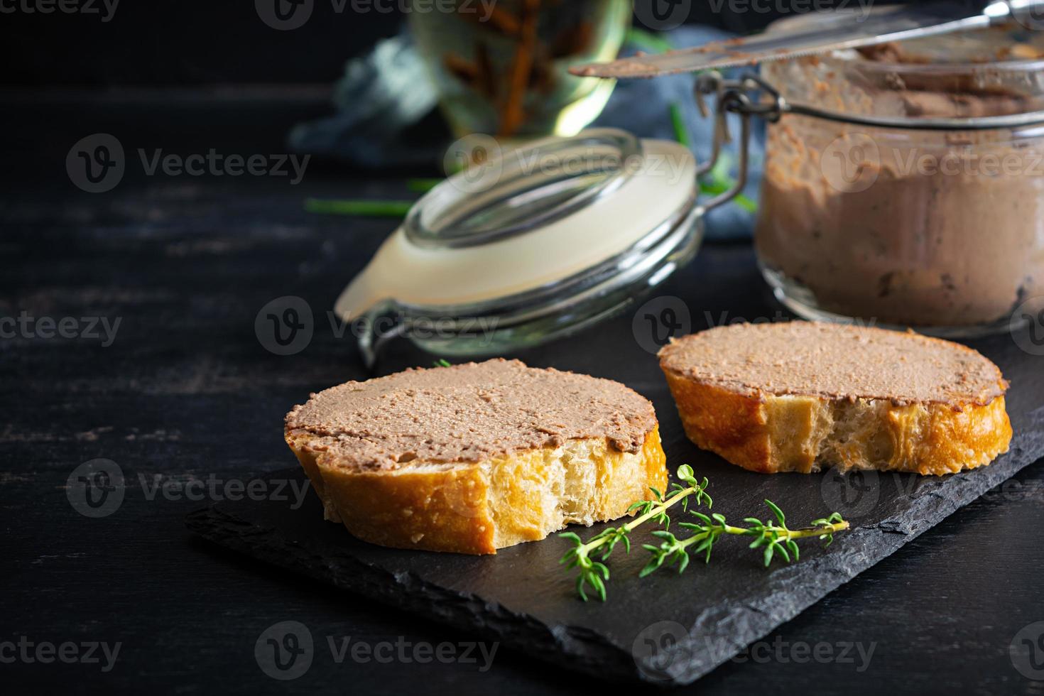 Sandwich with chicken liver pate on dark background photo