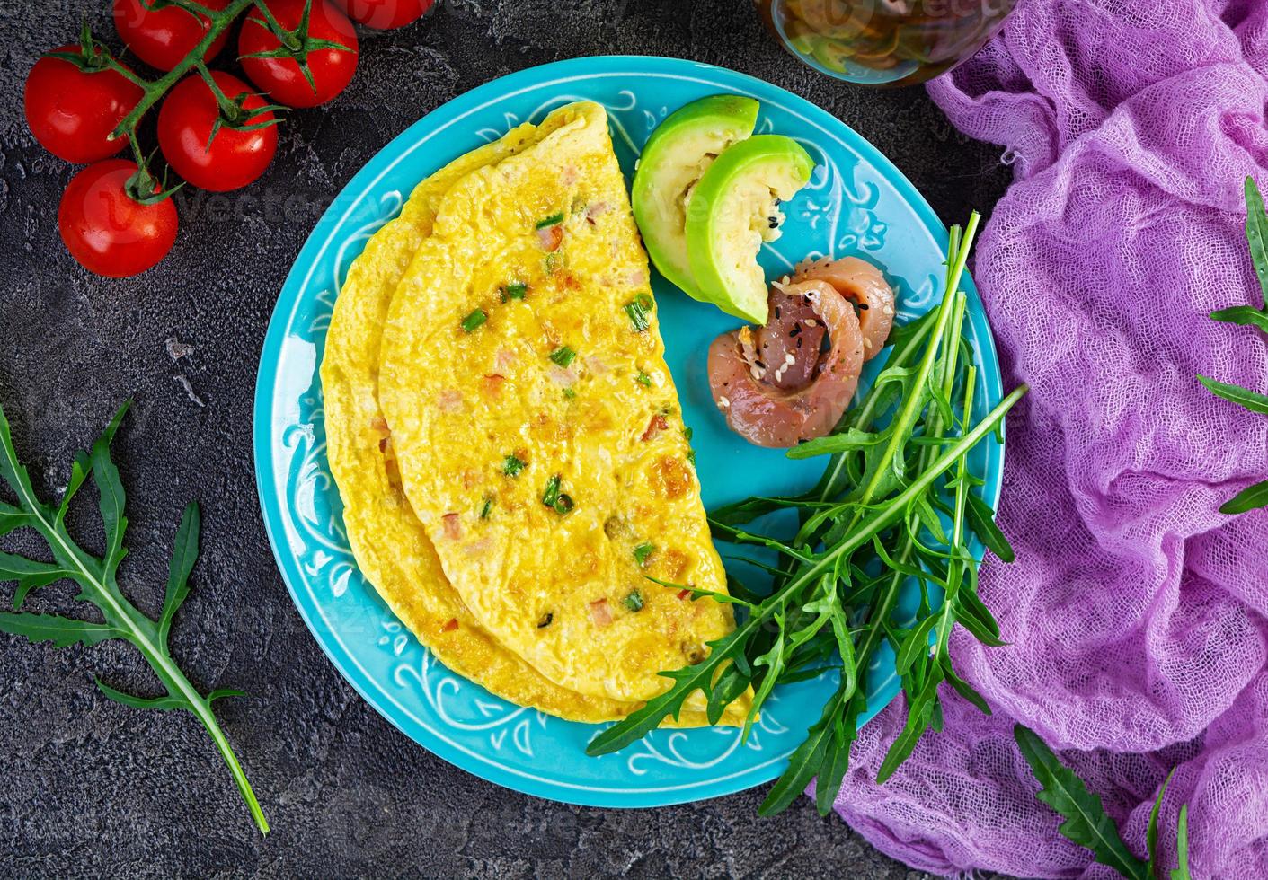 Fried omelette with ham, onion and herbs. Breakfast with scrambled eggs photo