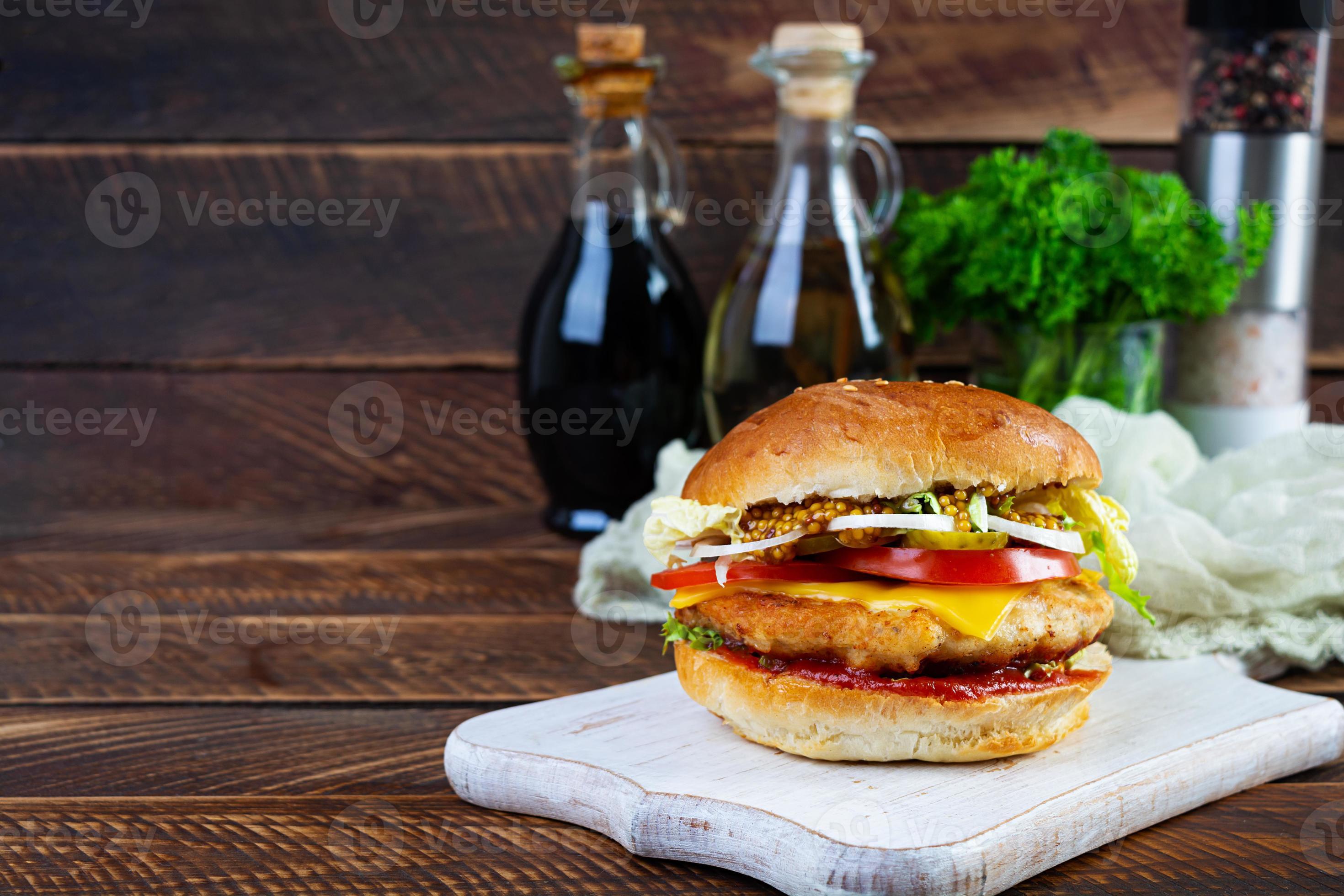 Tasty chicken burger with lettuce, cheese, tomato and pickle. Fast food