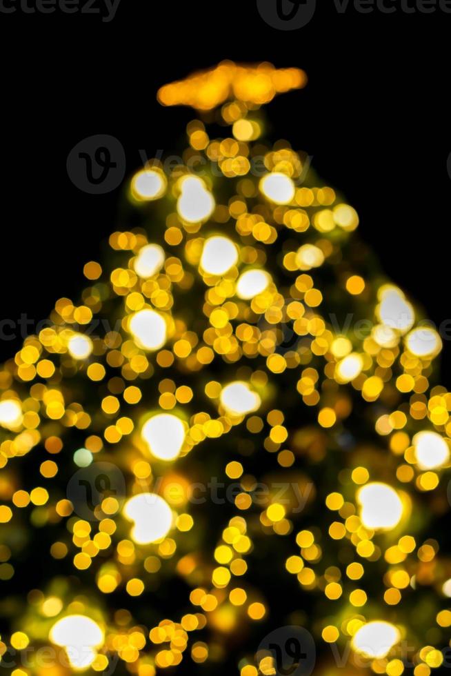 Look up view blurred and bokeh of Christmas lighting on Christmas tree and black background. photo