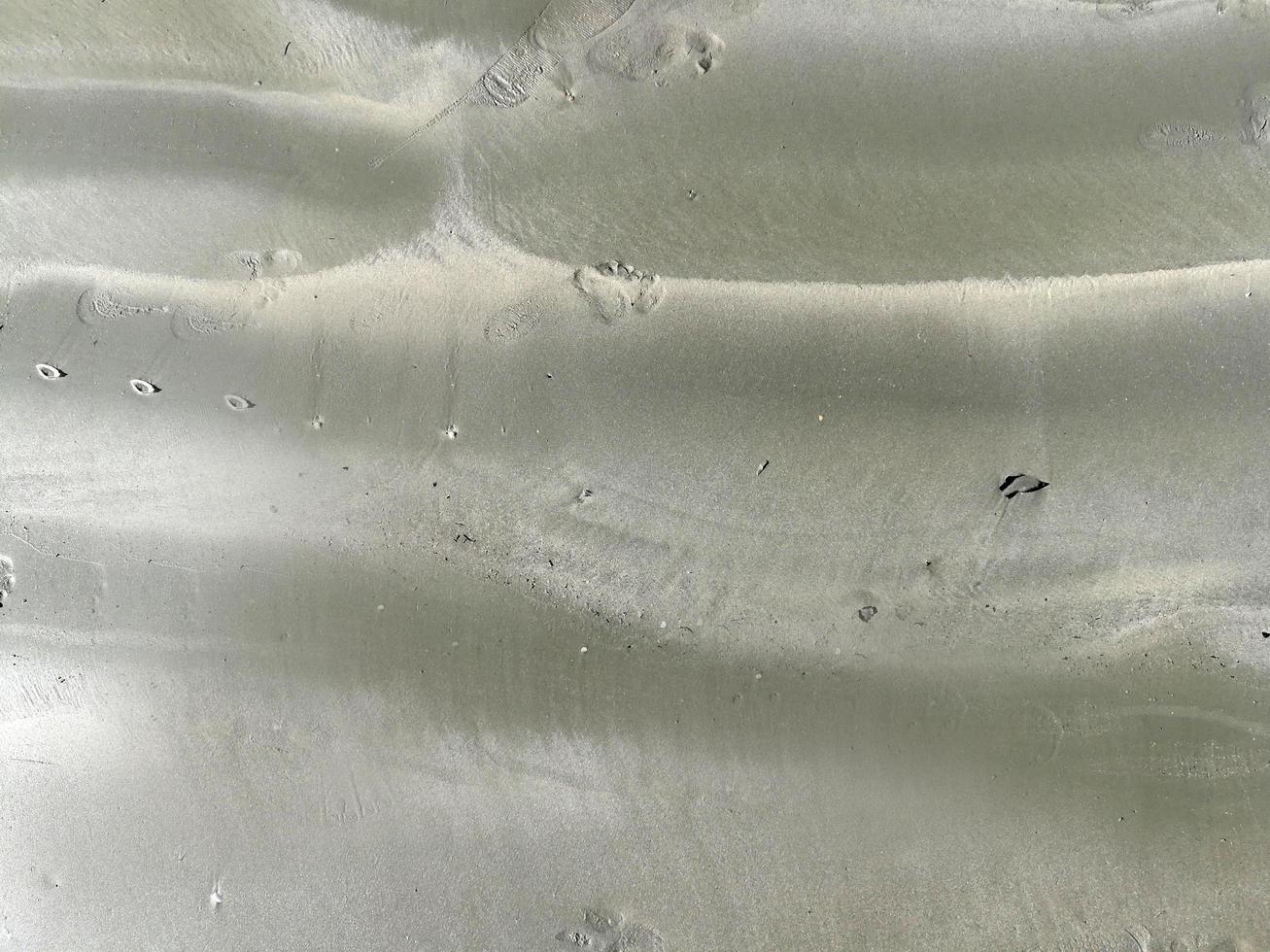 closeup texture of gray sand beach background with sun light on summer photo