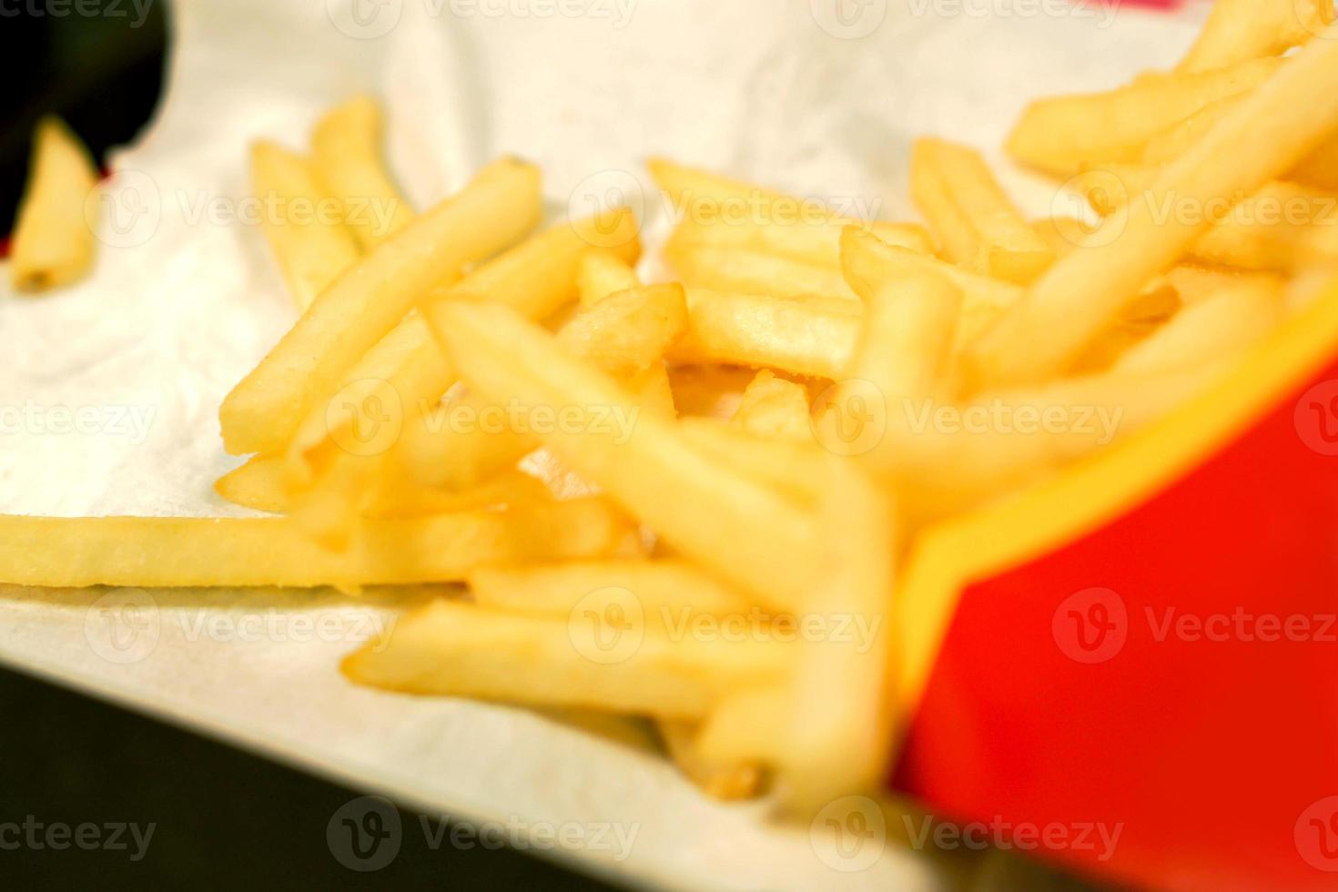 patatas fritas de comida rápida sobre papel blanco y fondo negro. foto