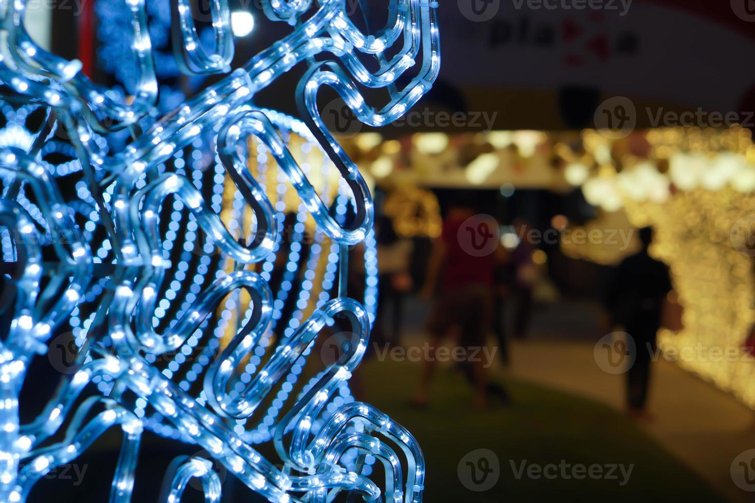 primer plano y cultivo decorado con led de iluminación azul de navidad en forma de copo de nieve sobre fondo borroso. foto