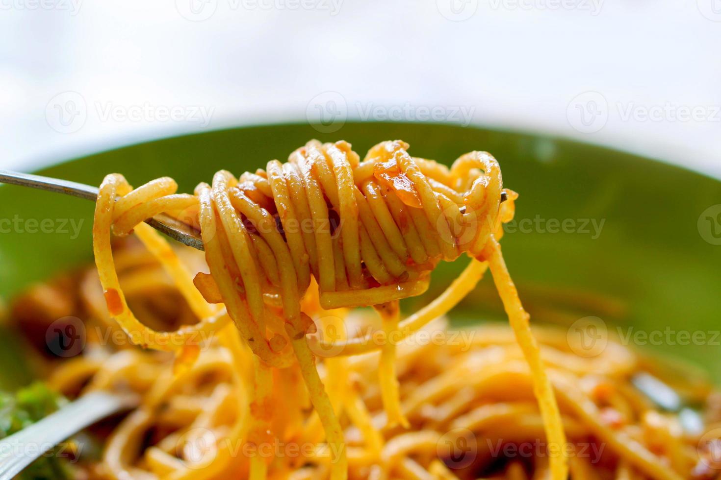 Spaghetti with minced pork and tomato sauce look tasty on the fork. photo