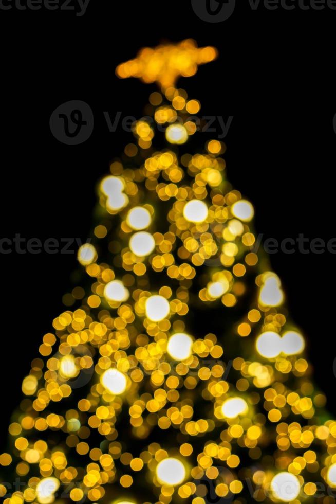 Look up view blurred and bokeh of Christmas lighting on Christmas tree and black background. photo