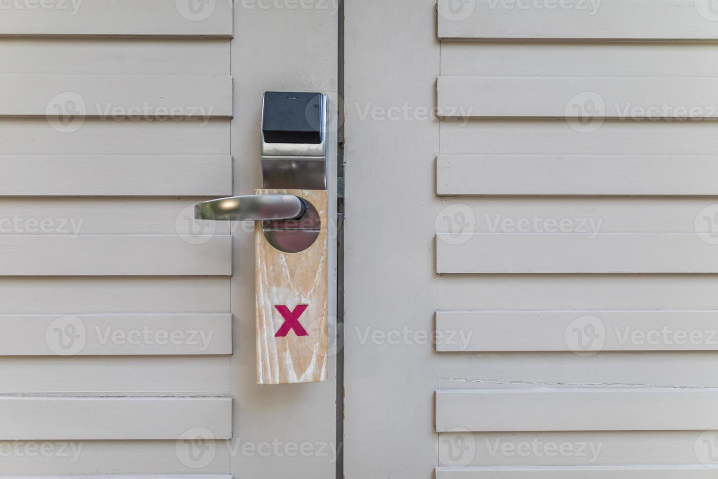 Hotel electronic card lock with do not disturb sign. Modern stainless with card insert handle on wood door photo