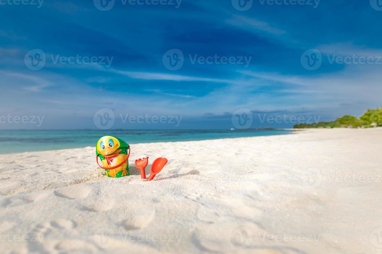 juguetes de playa para niños: baldes, palas y palas en la arena en un día soleado. vacaciones en la playa de la isla tópica, fondo de turismo. lindos juguetes de playa foto