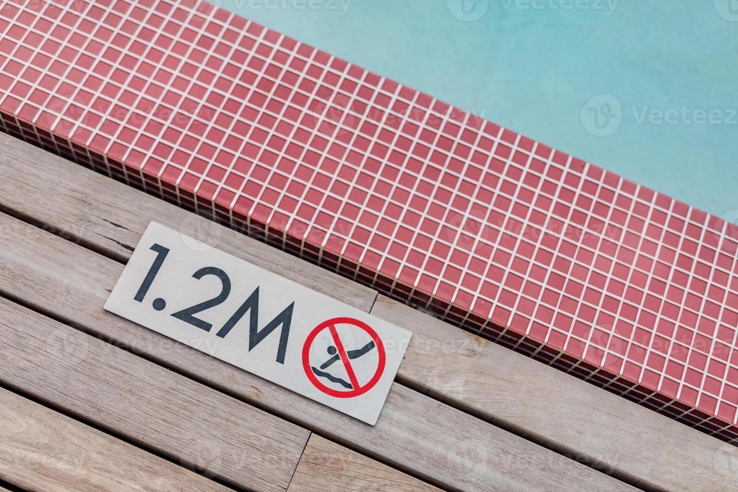 Sign showing 1.2 meter depth on edge of blue swimming pool with no diving. photo