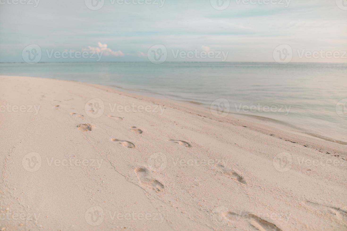 Footprints in the sand at sunset. Beautiful sandy tropical beach with