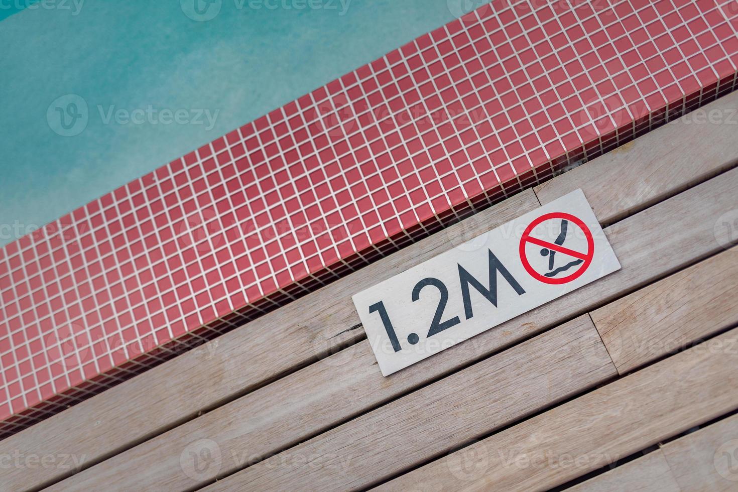 Sign showing 1.2 meter depth on edge of blue swimming pool with no diving. photo