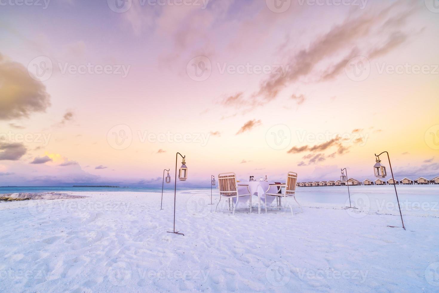 Seaside view under sunset light with dining table with infinity pool around. Romantic tropical getaway for two, couple concept. Chairs, food and romance. Luxury destination dining, honeymoon template photo