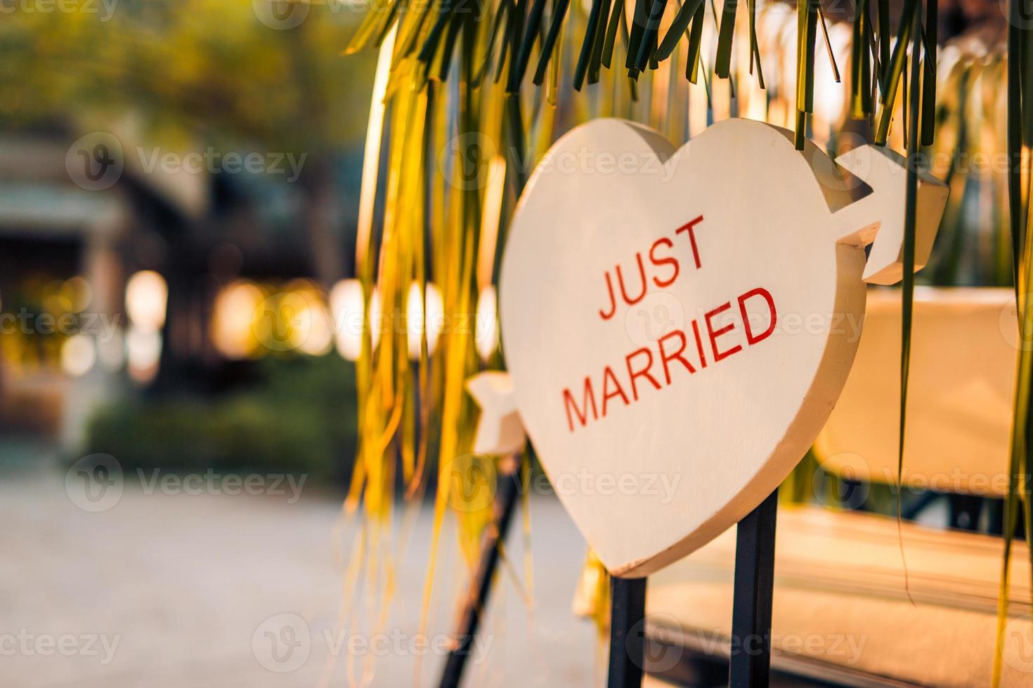 Just Married sign on tropical background back of a gulf cart, sunset light, romantic mood. Honeymoon and wedding concept, newlyweds design template photo