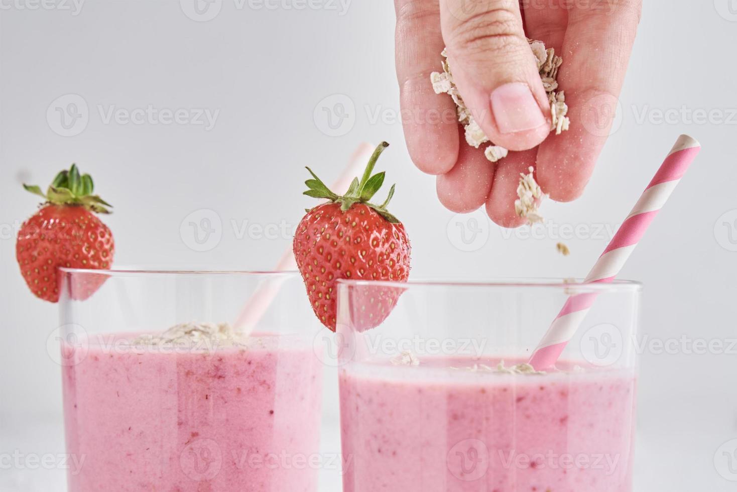 batido de fresa en vaso con paja y bayas frescas foto