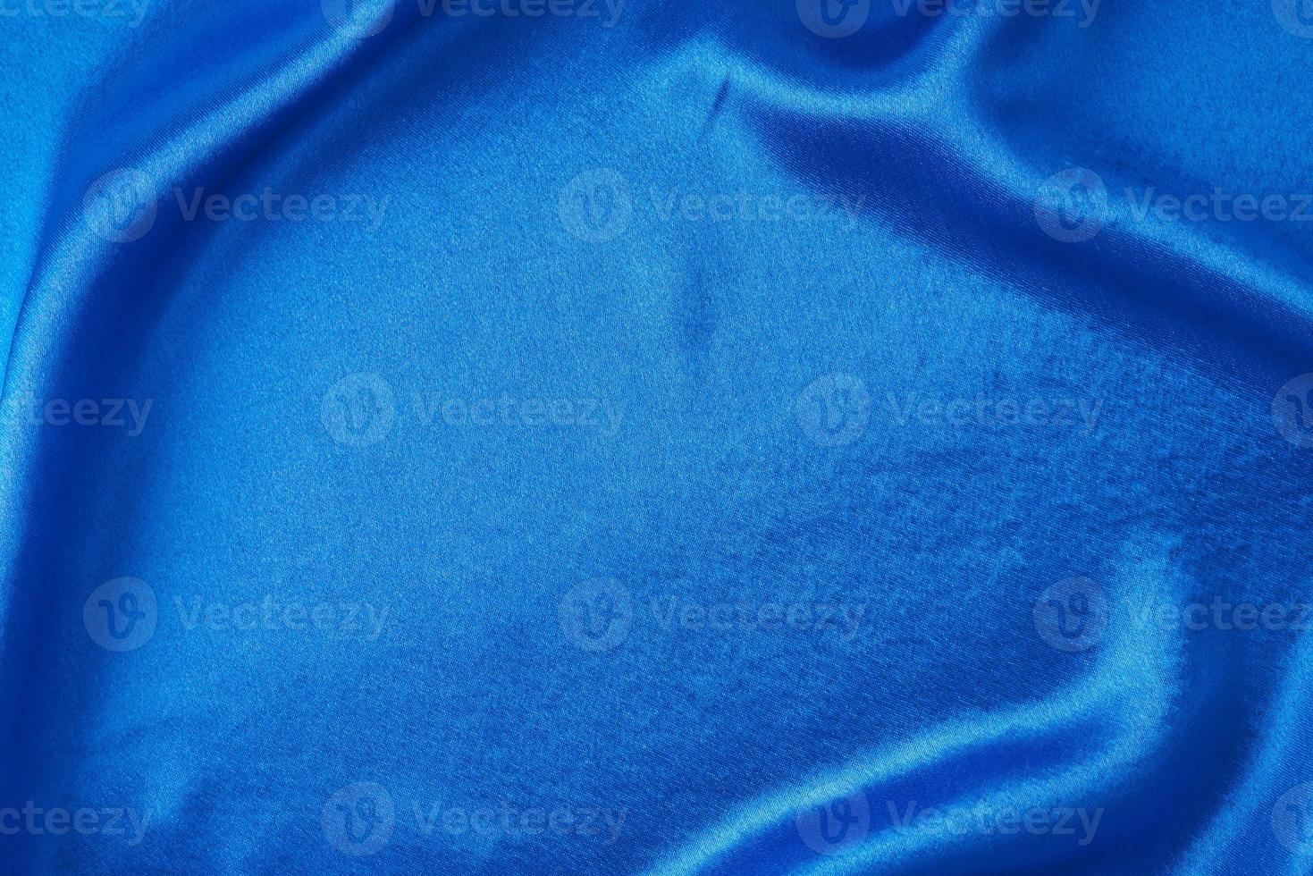 fondo de seda azul con pliegues. textura abstracta de superficie satinada ondulada foto