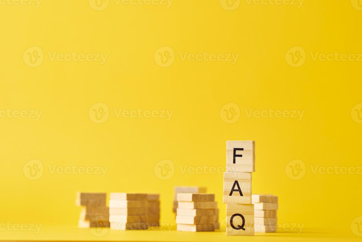 Wooden blocks with word FAQ on the yellow baclground. photo