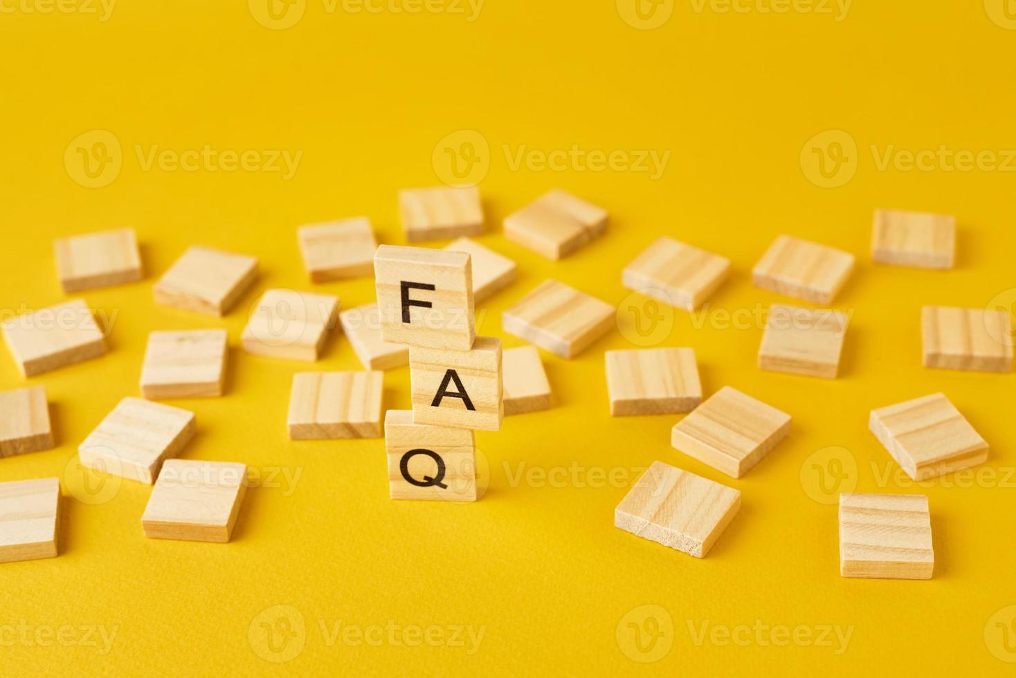 Wooden blocks with word FAQ on the yellow baclground. photo