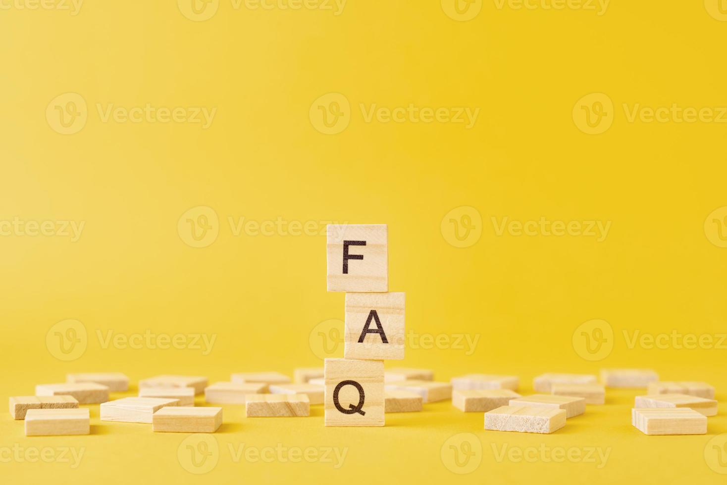 Wooden blocks with word FAQ on the yellow baclground. photo