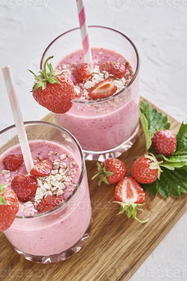 Strawberry milk shake in glass with straw and fresh berries photo