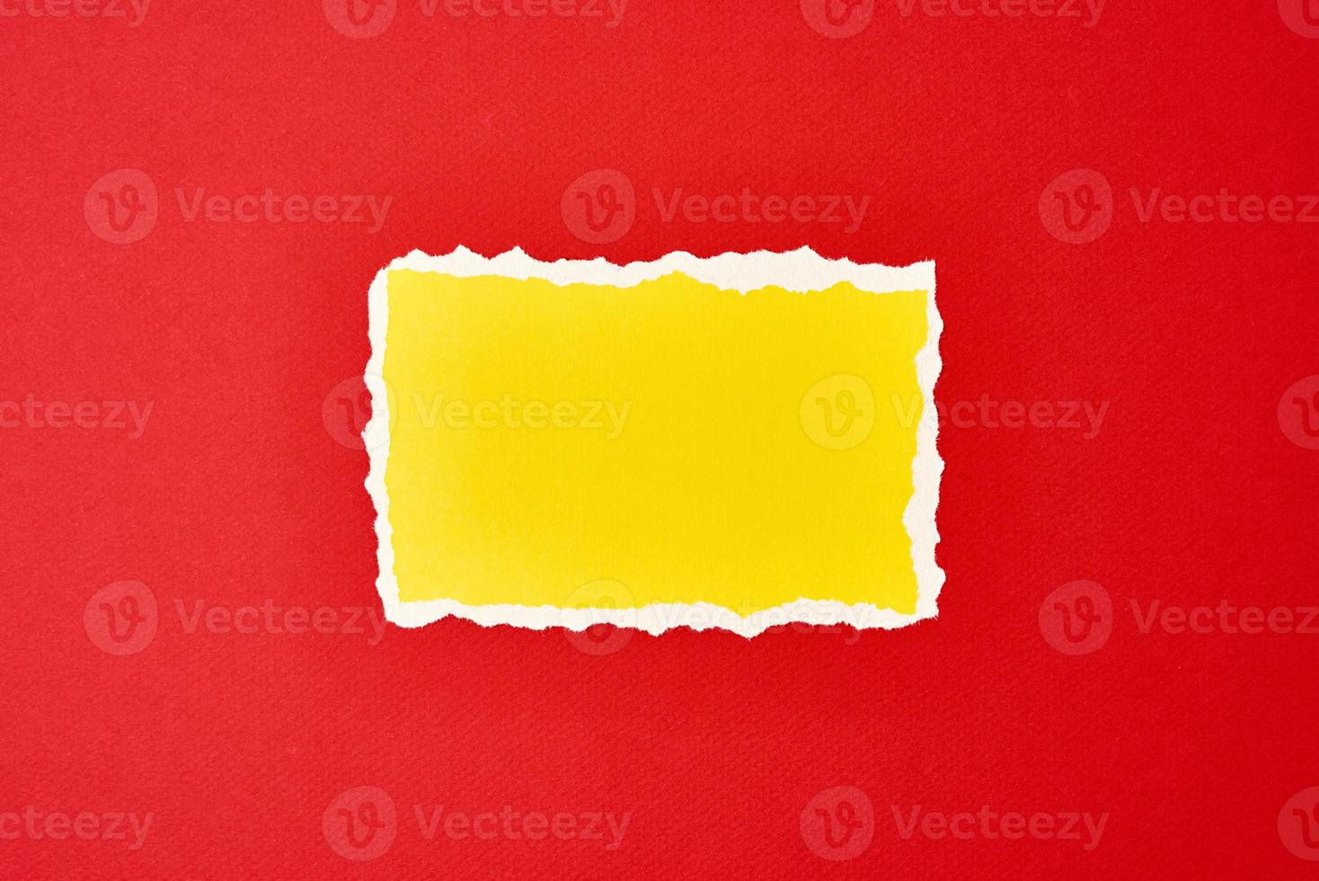 papel amarillo rasgado hoja de borde rasgado sobre un fondo rojo. foto