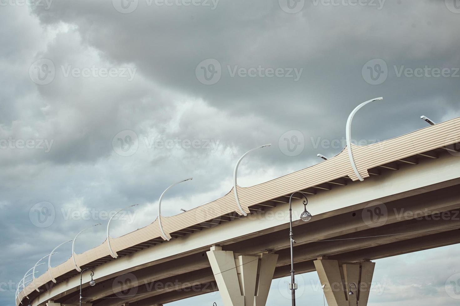 parte del puente moderno con luces de calle contra el cielo nublado. foto