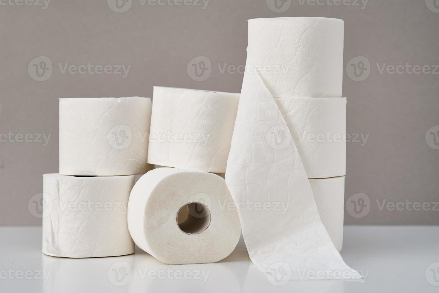 rollos de papel higiénico apilados sobre un fondo gris. concepto de higiene foto