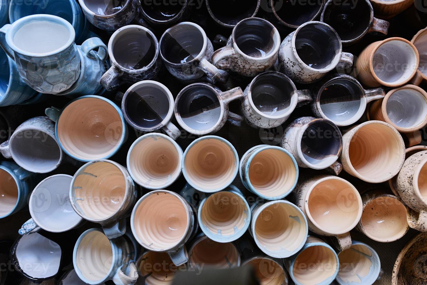 muchas tazas de cerámica coloridas hechas a mano, vista superior foto