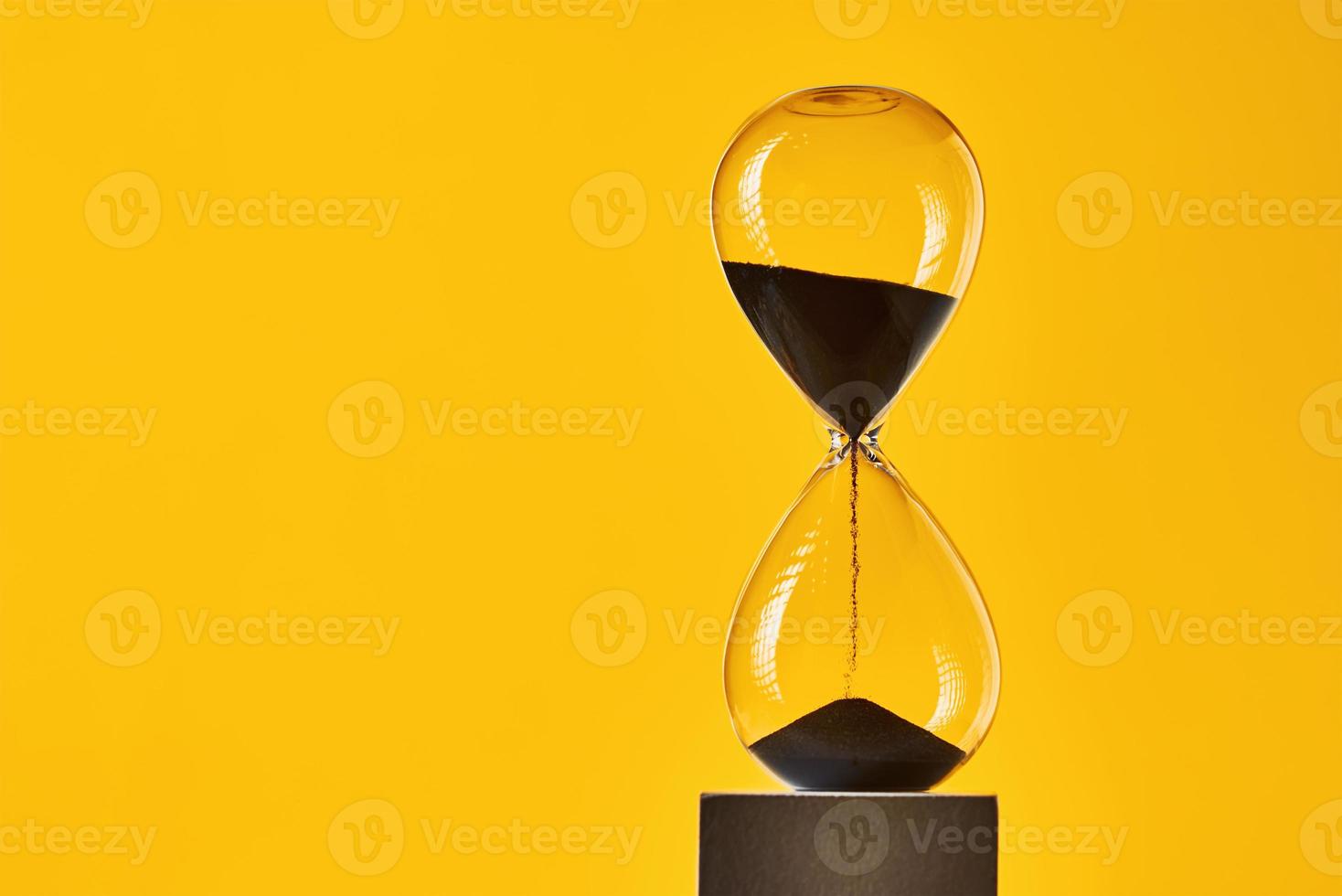 Hourglass on the yellow background with copy space photo