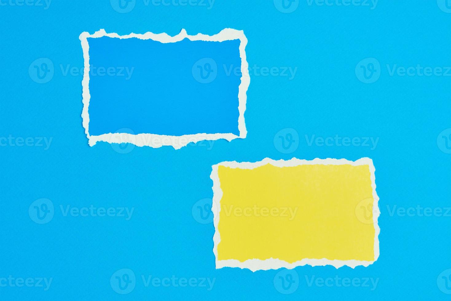 Two ripped paper torn edge sheets on a blue background. photo