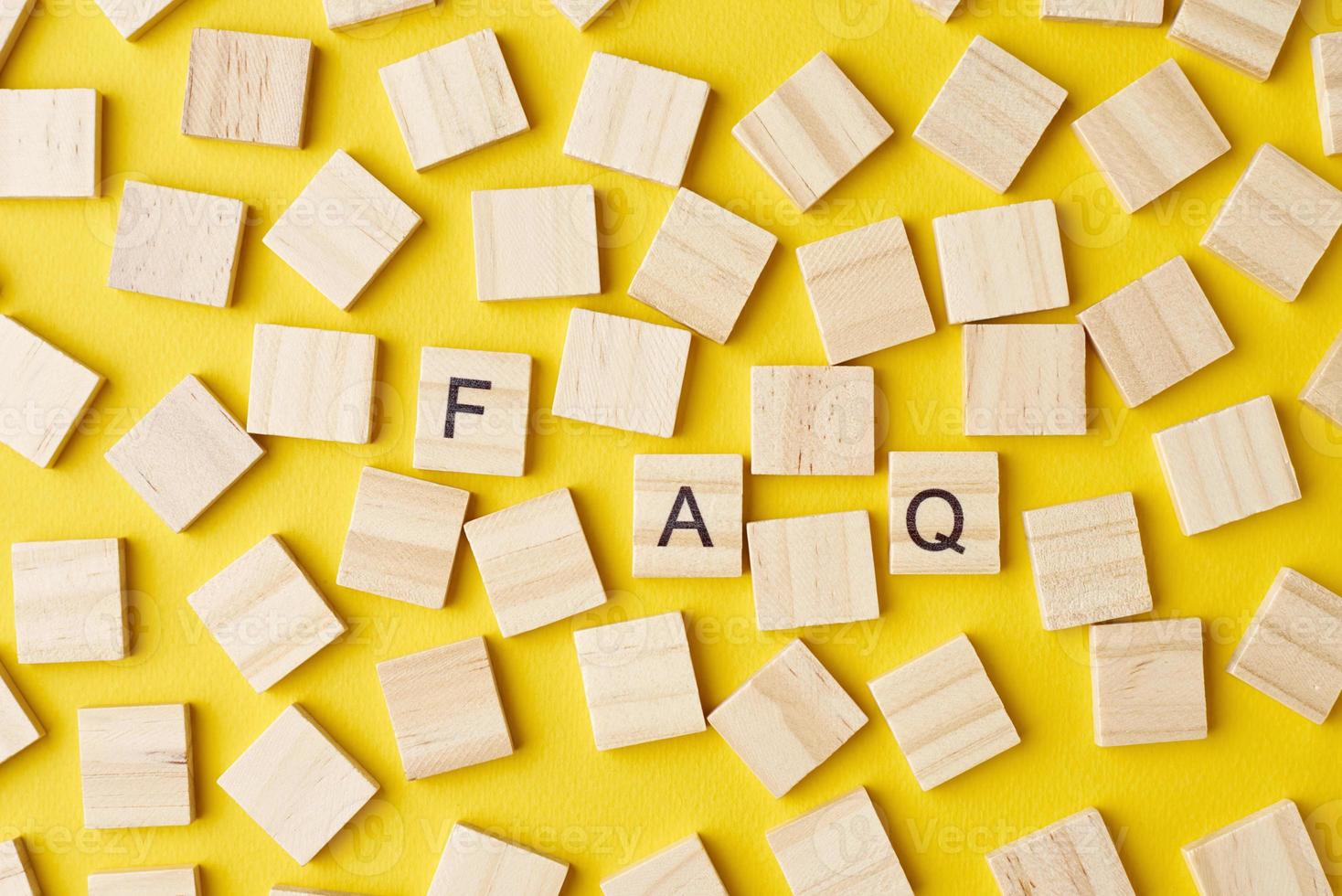 Wooden blocks with abbreviation FAQ on the yellow background, top view. photo