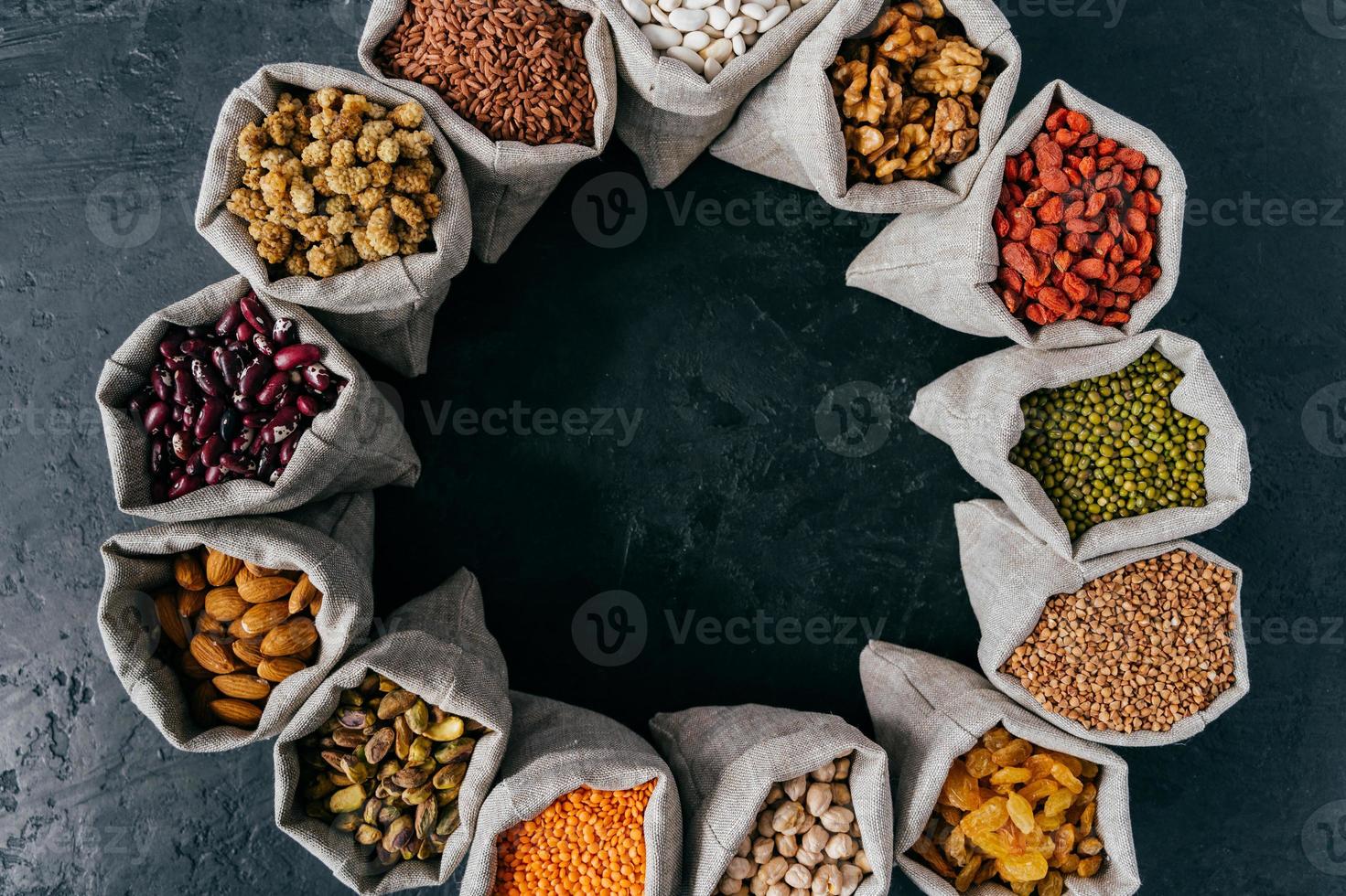 Food and nutrition concept. Horizontal shot of sacks filled with protein rich dried fruits and legumes. Almonds, walnuts, raisins, pink seeds. photo