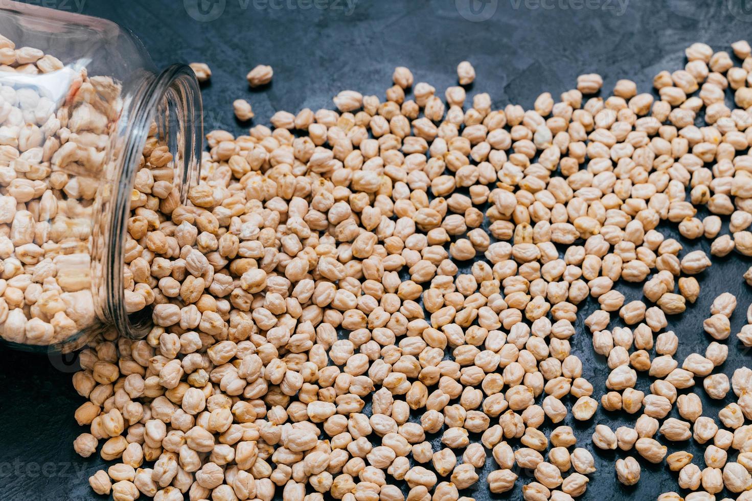 garbanzos derramados sobre fondo oscuro. comida vegetariana rica en