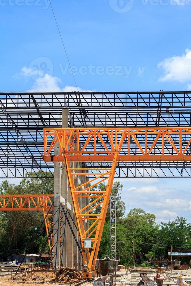 La grúa de pórtico estructural de acero pesado para mover grandes losas en una peligrosa fábrica de fundición de losas se está construyendo fuerte y estable contra un hermoso fondo de cielo nocturno. foto