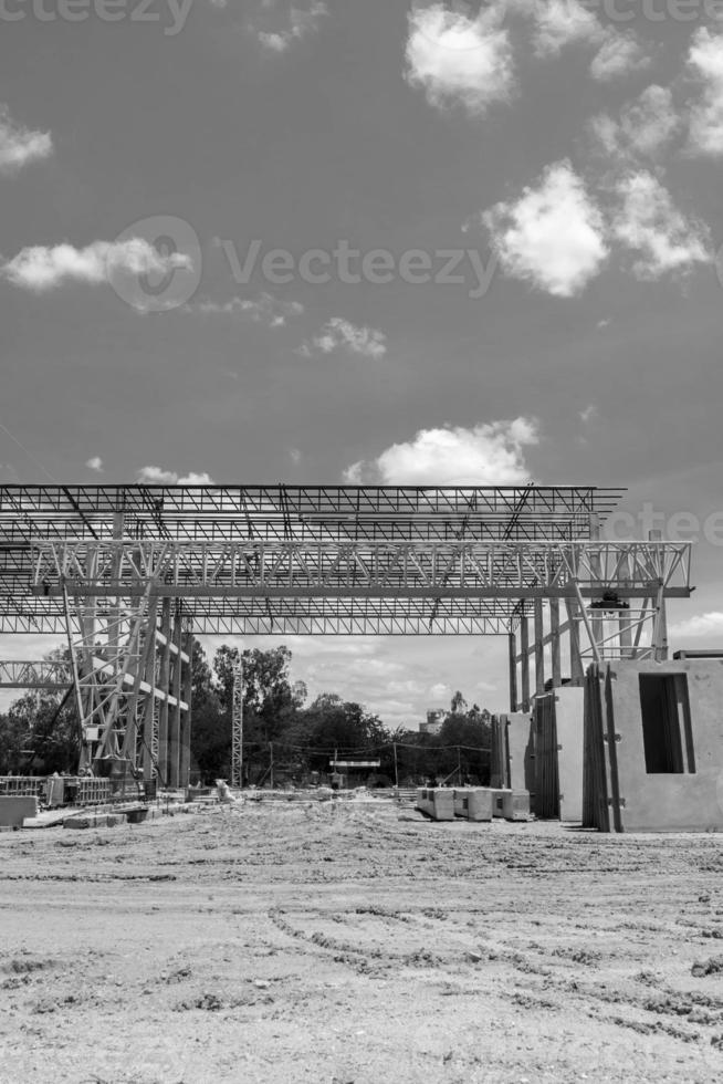 La grúa de pórtico estructural de acero pesado para mover grandes losas en una peligrosa fábrica de fundición de losas se está construyendo fuerte y estable contra un hermoso fondo de cielo nocturno. foto