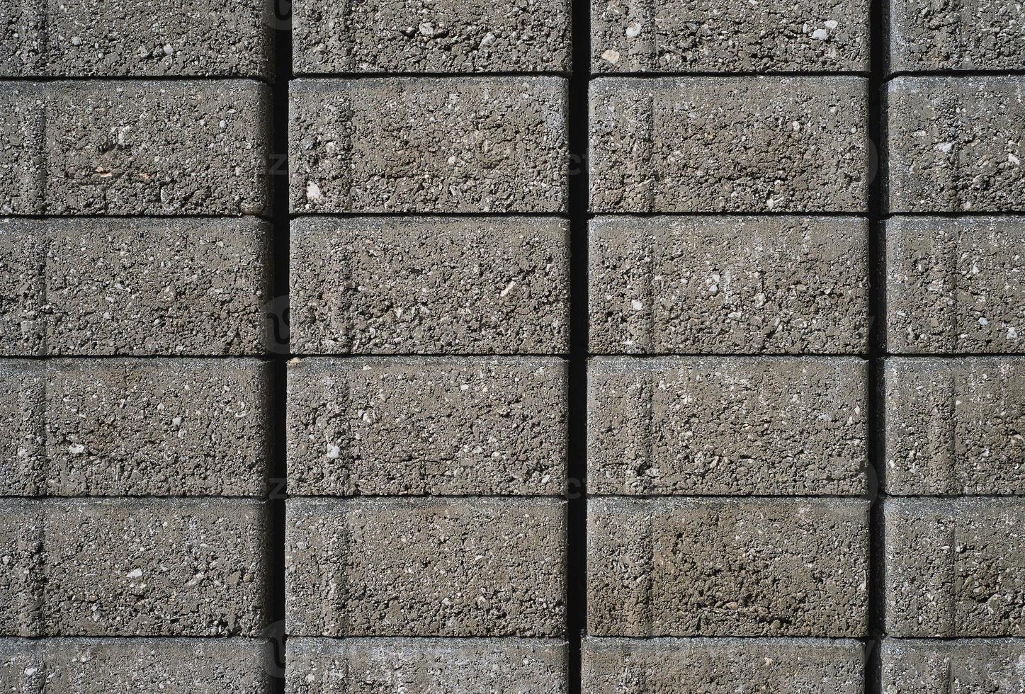 Gray paving slabs on a pallet, close-up. Stack of paving slabs in warehouse, road repair or finished tile sale, space for text photo
