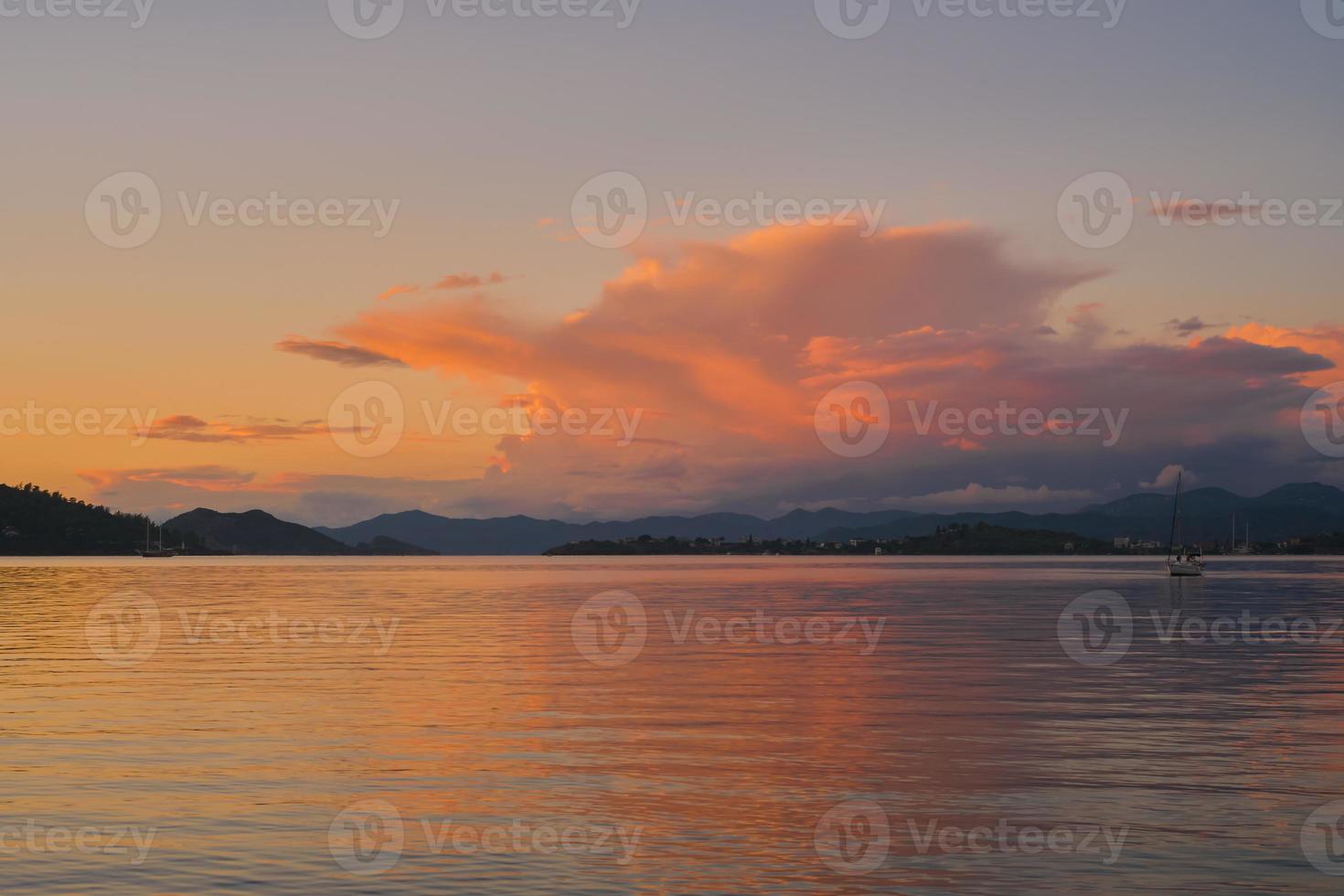 Evening warm landscape of Fethiye Bay, blurred background of a mountain range and cumulus clouds in the rays of the sun, an idea for a background photo