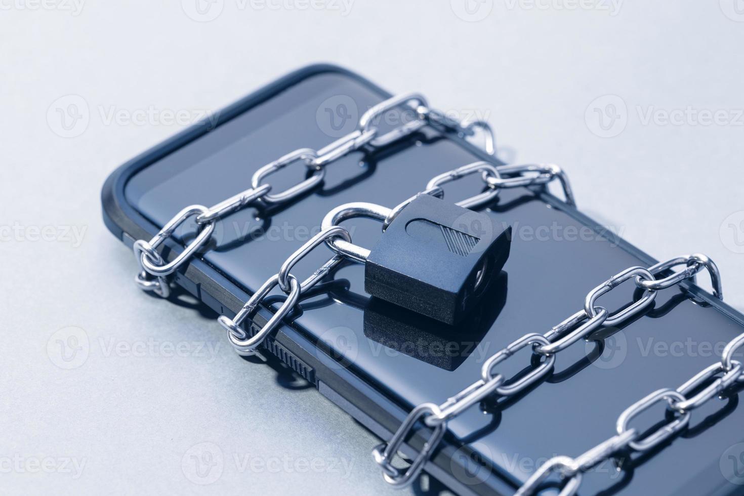 Phone security and data privacy concept. Smartphone locked with chain and padlock photo
