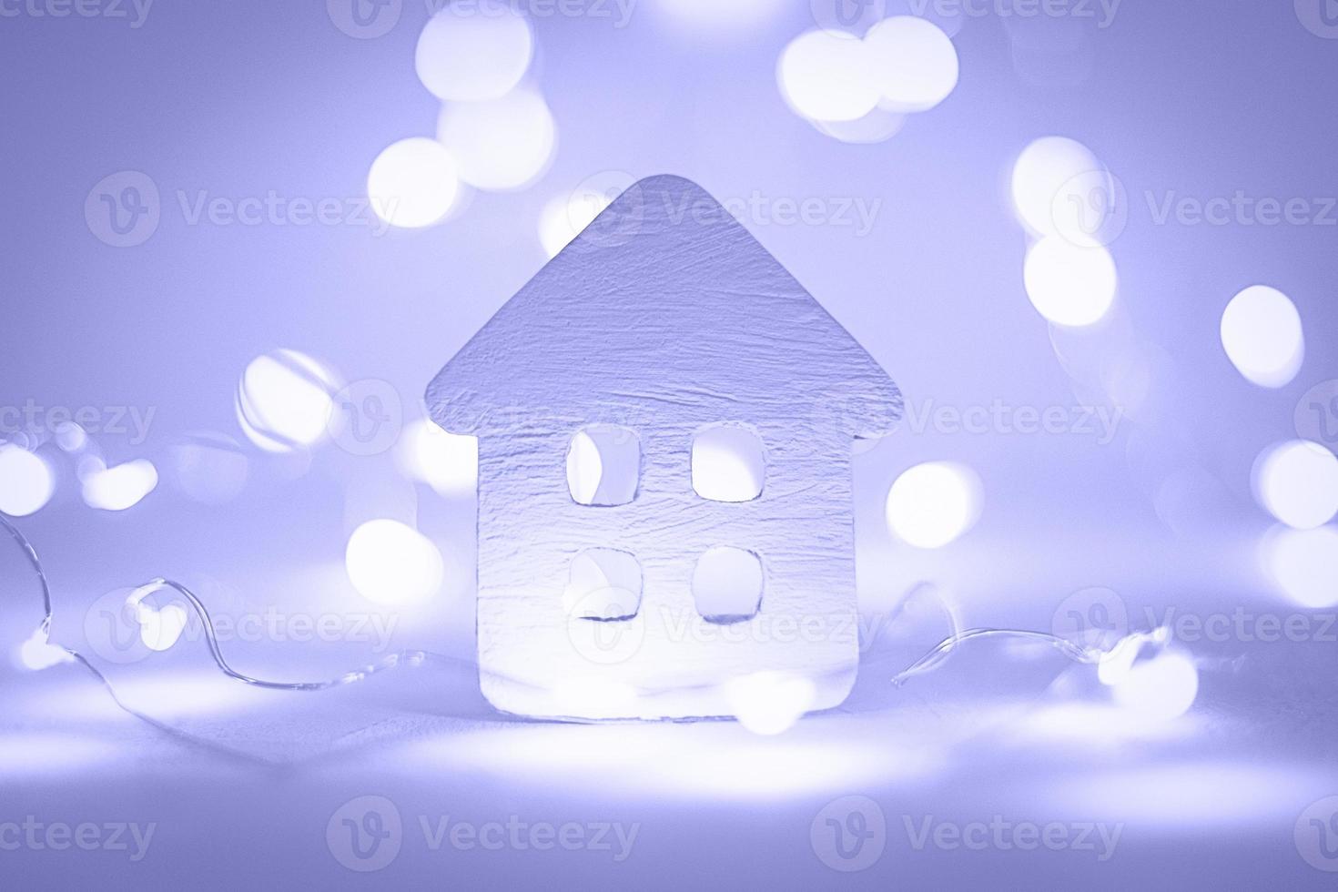 Paper house with Christmas garland purple lights, winter holidays, wintertime mood photo
