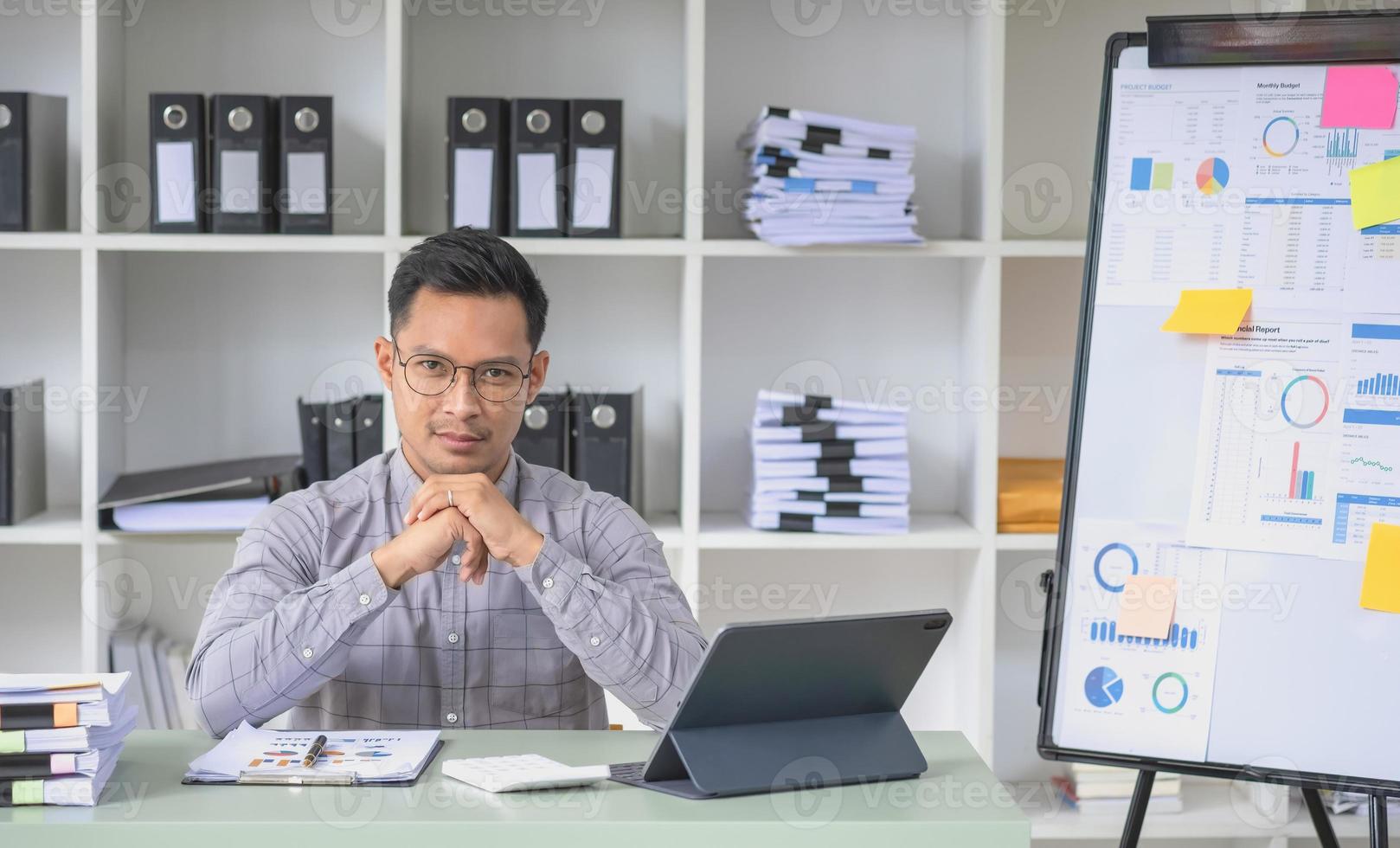 Marketing, Financial, Accounting, Planning, The president of the company sits in his office with a tablet, calculator, pen and graph paper attached to a blackboard for his work. photo