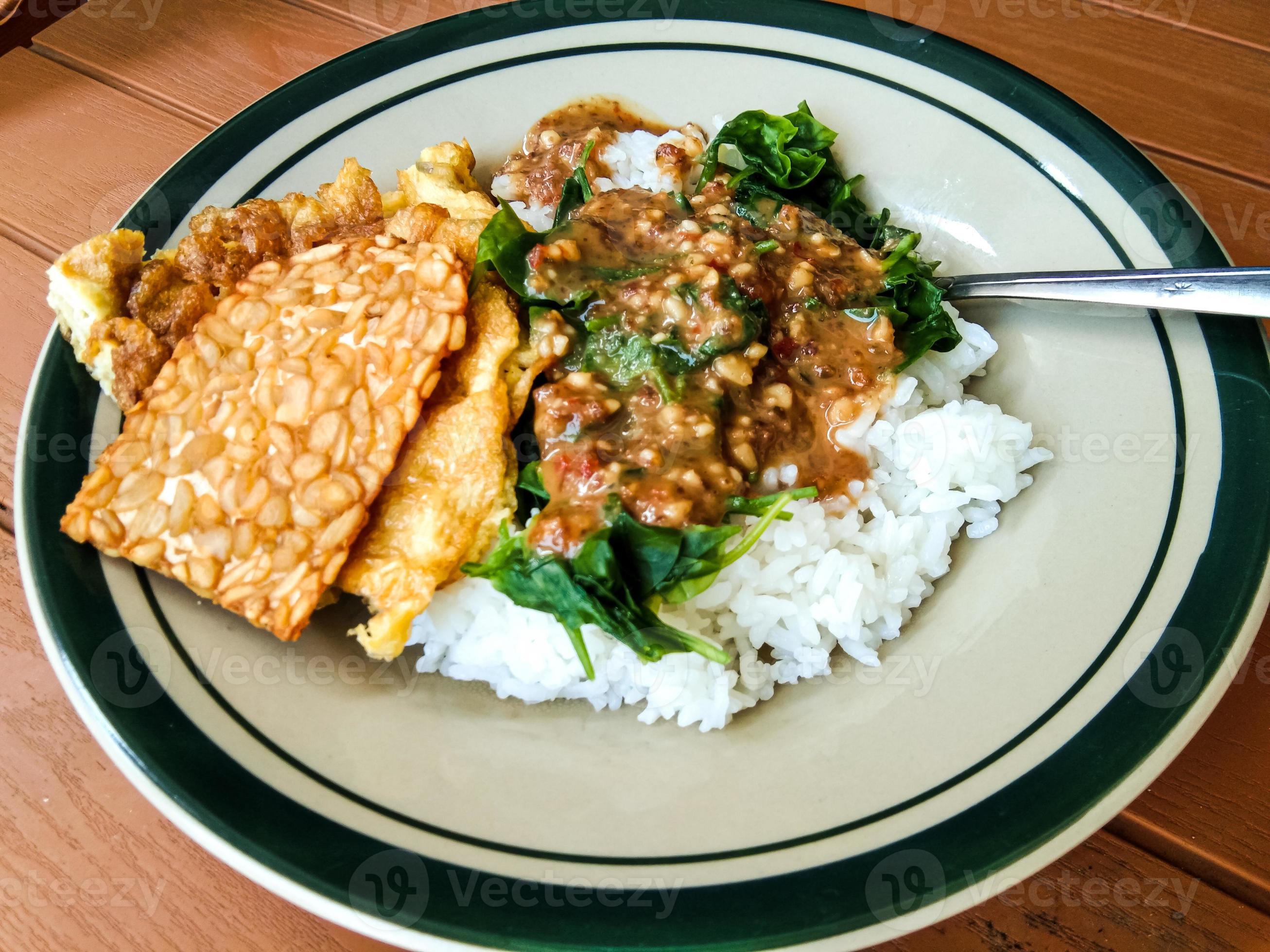 pecel rice with side dishes of tempeh and scrambled eggs 15182023 Stock