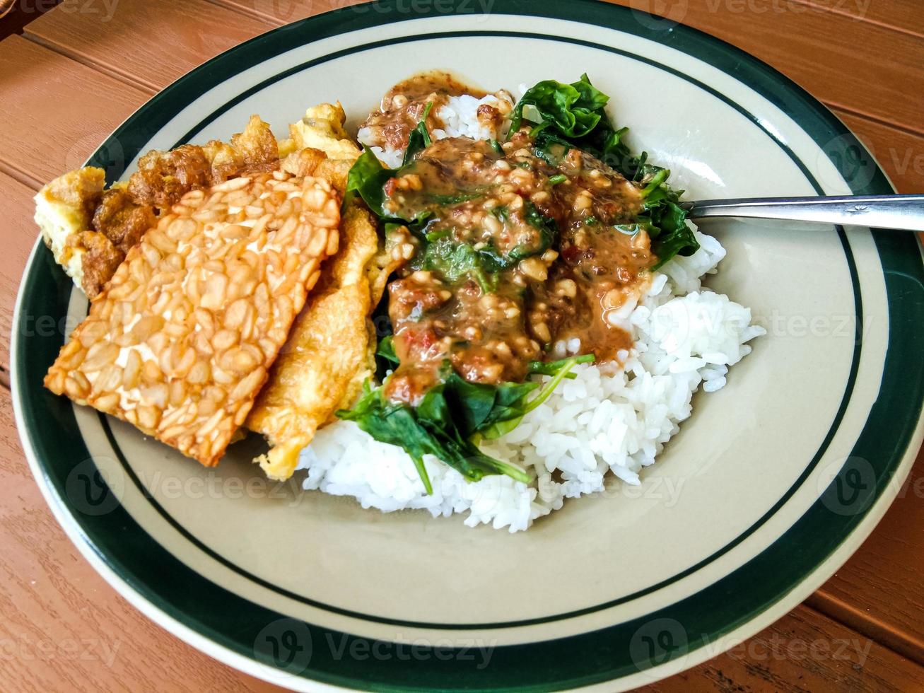 pecel rice with side dishes of tempeh and scrambled eggs 15182023 Stock