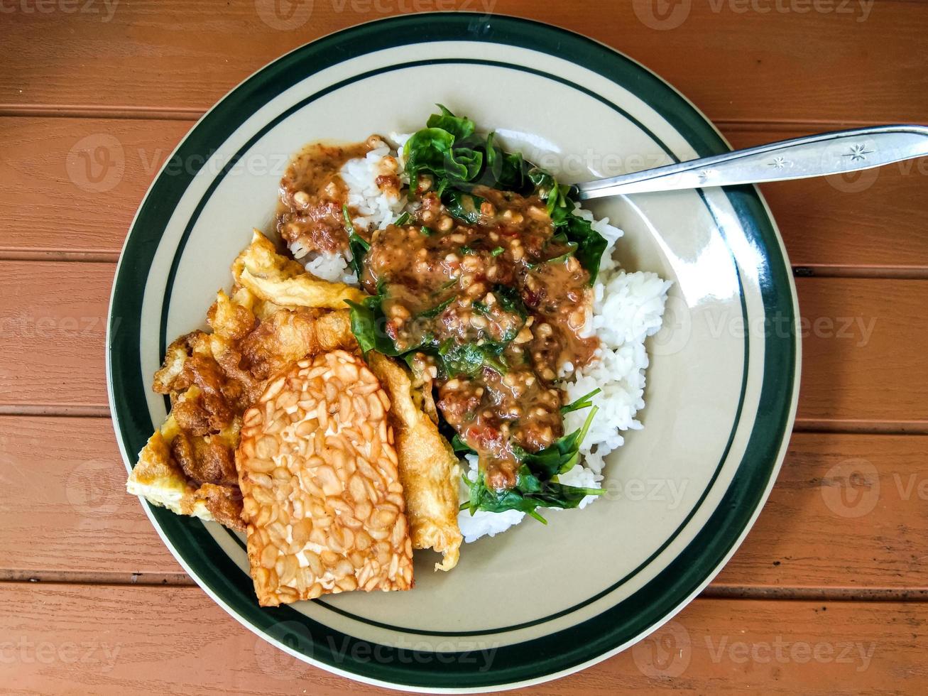 pecel rice with side dishes of tempeh and scrambled eggs 15182025 Stock