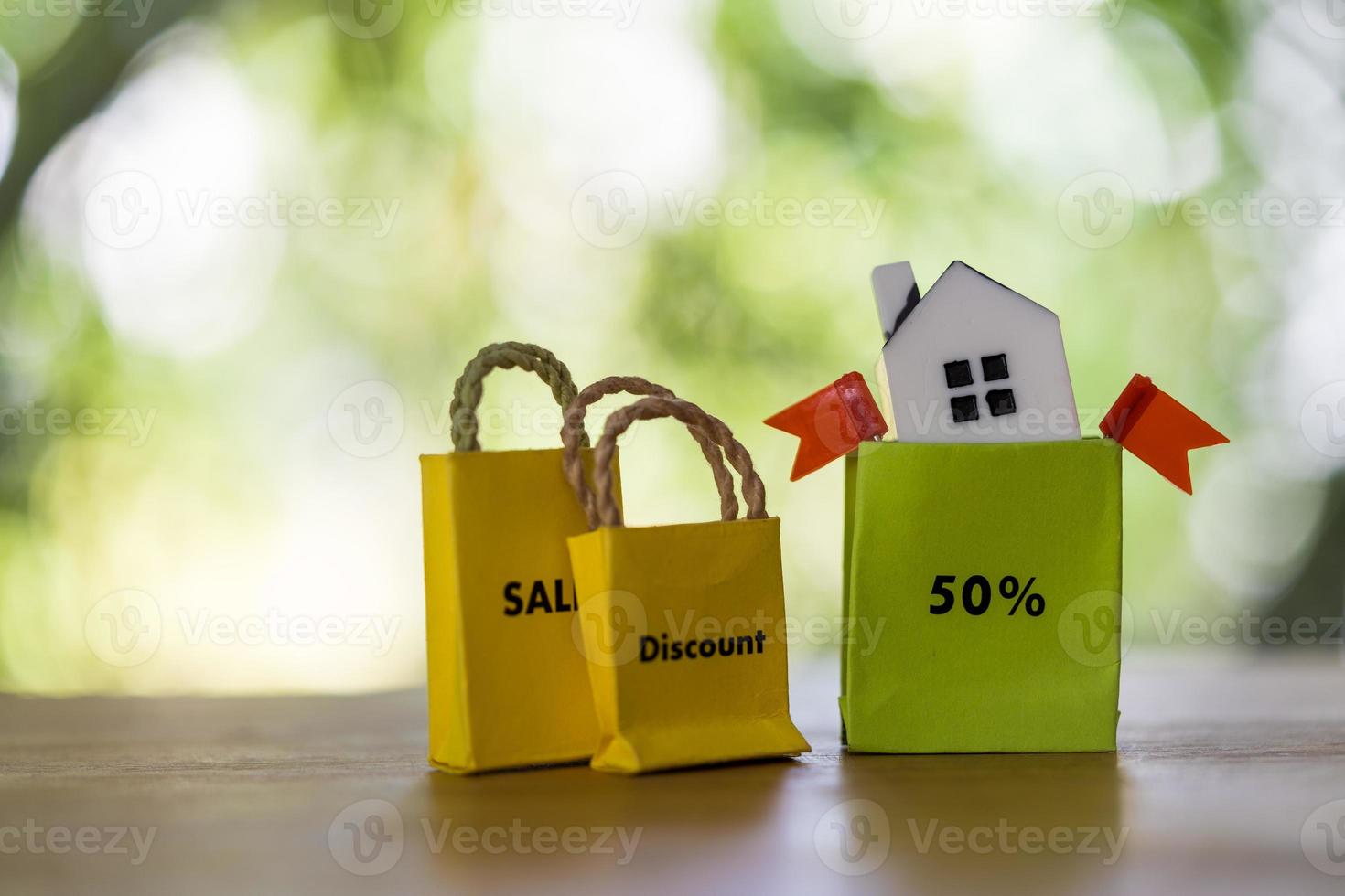 Concept of discounts on real estate. Discounts fifty percent. Low cost real estate. House in the paper bag shopping photo