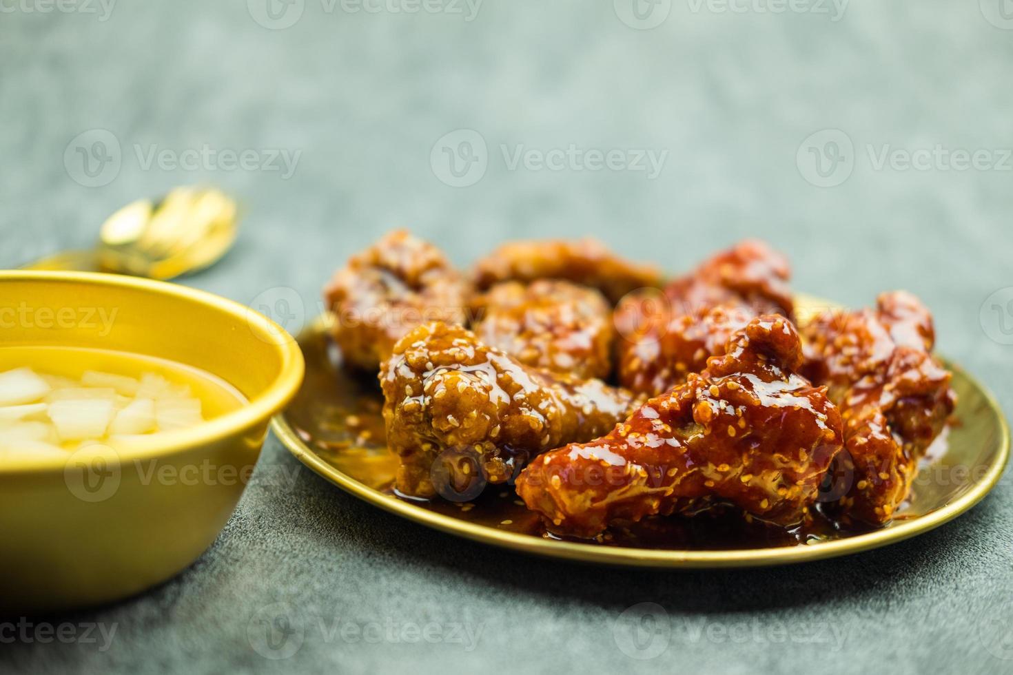 Deep fried chicken wing with garlic sauce and spicy sauce in Korean style served with pickled radish photo
