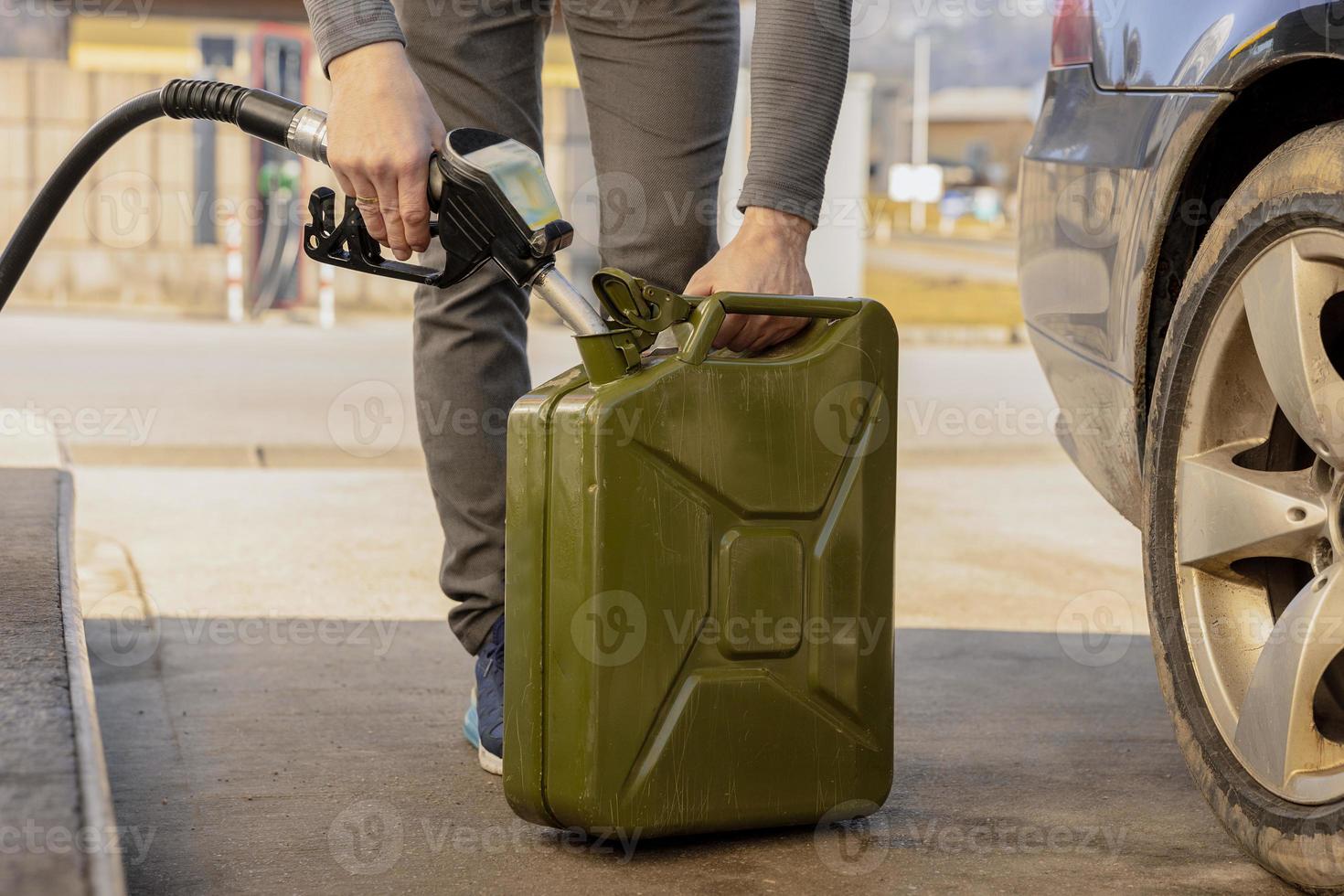 Refilling canister with fuel on the petrol station. Close up view. Fuel, gasoline, diesel is getting more expensive. Petrol industry and service. Petrol price and oil crisis concept. photo