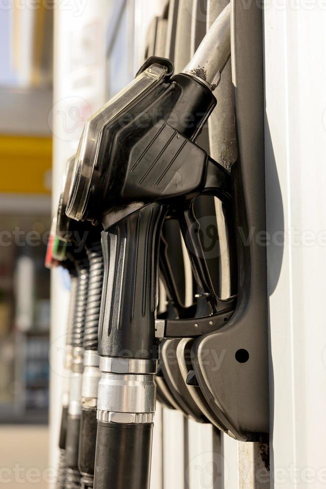 Boquillas de combustible en la gasolinera. vista de cerca el combustible, la gasolina, el diesel cada vez es más caro. industria y servicio de gasolina. precio de la gasolina y concepto de crisis del petróleo. foto